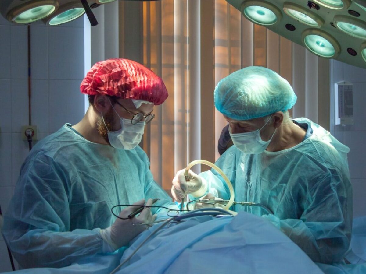 two men wearing blue lab coats