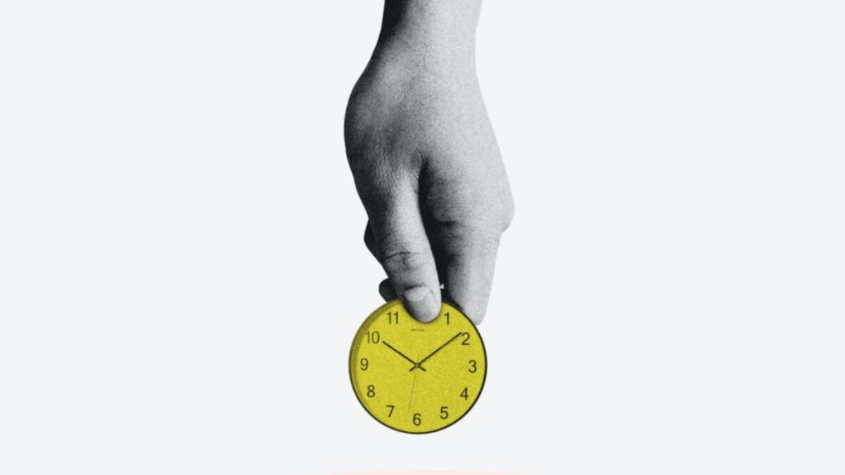 person holding yellow round analog clock