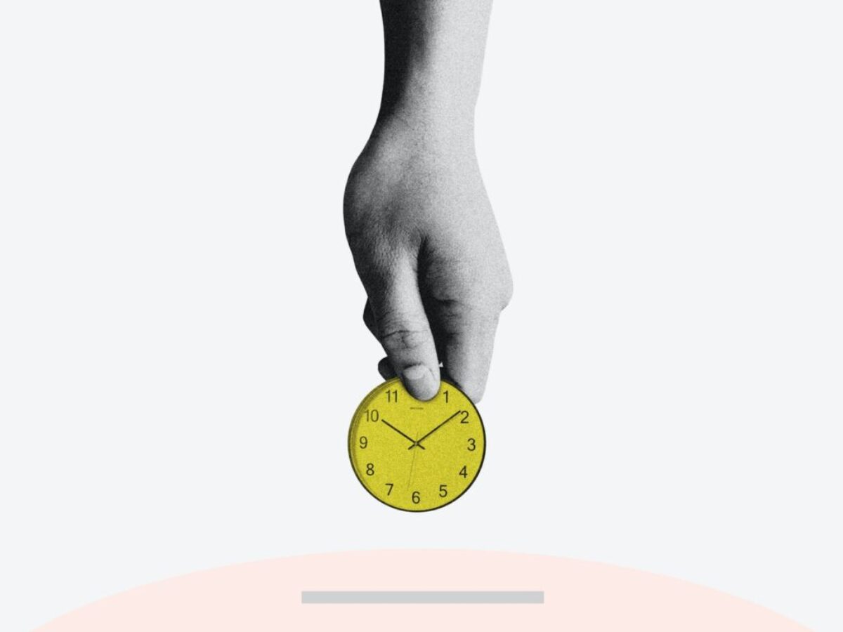 person holding yellow round analog clock