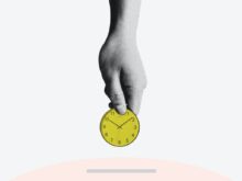 person holding yellow round analog clock
