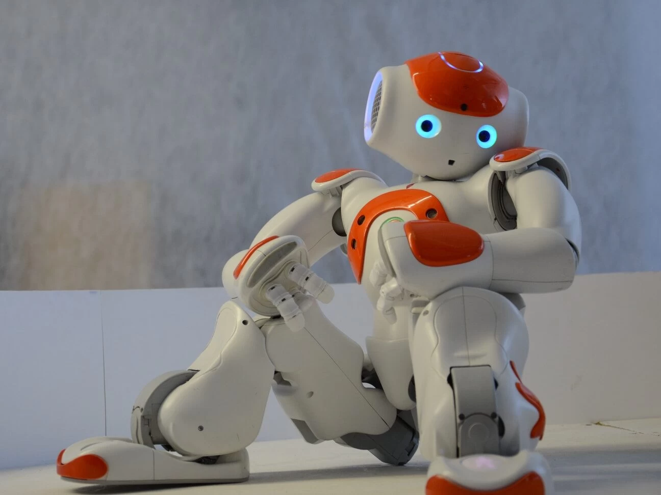 white and orange robot near wall