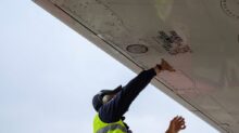man in green safety vest standing under white structure