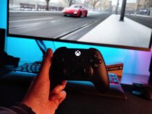 person holding black xbox one game controller