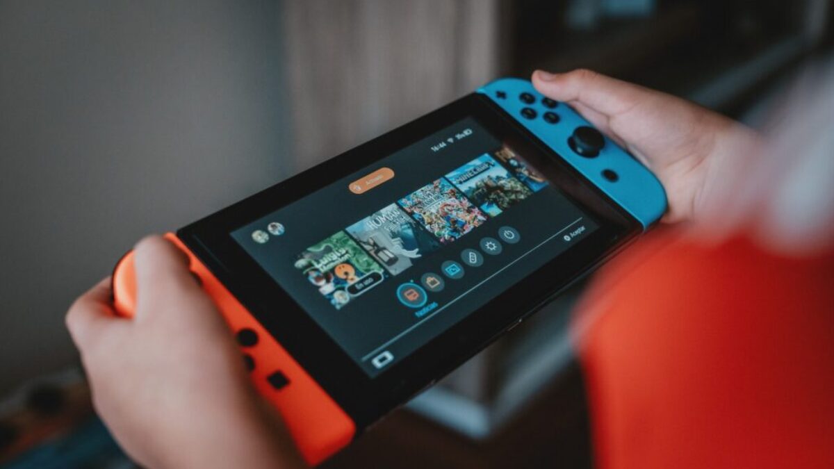 person holding black and orange nintendo switch