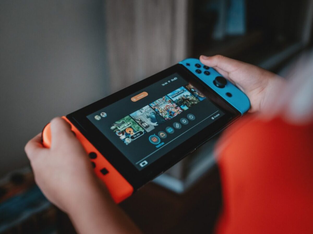 person holding black and orange nintendo switch