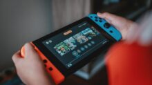person holding black and orange nintendo switch