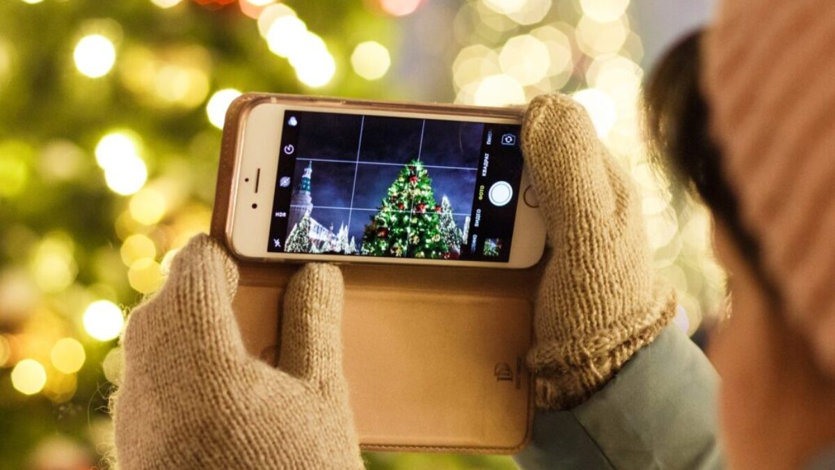 person taking photo of Christmas tree