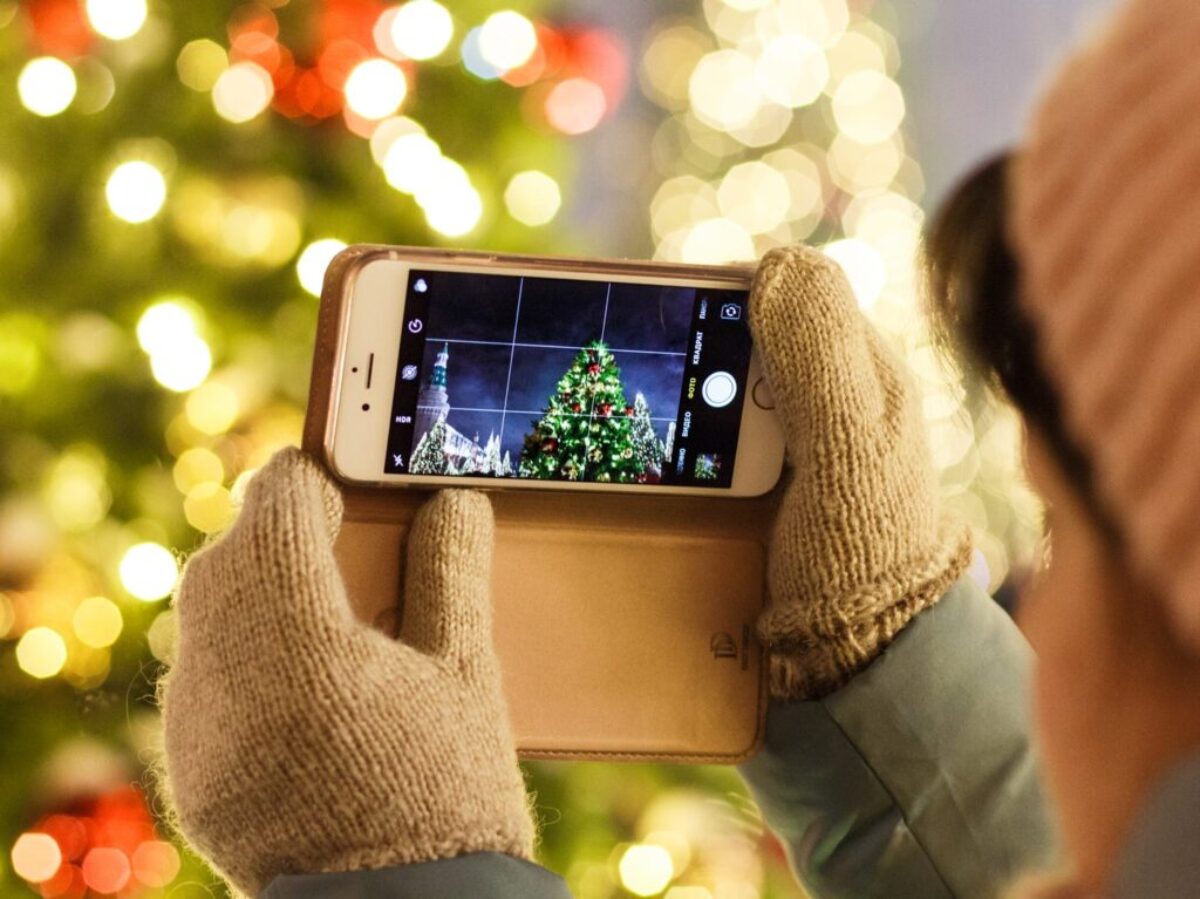 person taking photo of Christmas tree