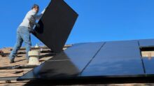 man in white dress shirt and blue denim jeans sitting on white and black solar panel