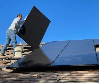 man in white dress shirt and blue denim jeans sitting on white and black solar panel