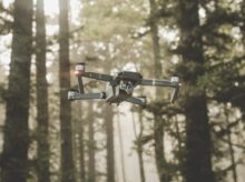 gray and black DJI Mavic Pro quadcopter drone on mid top air near forest at daytime
