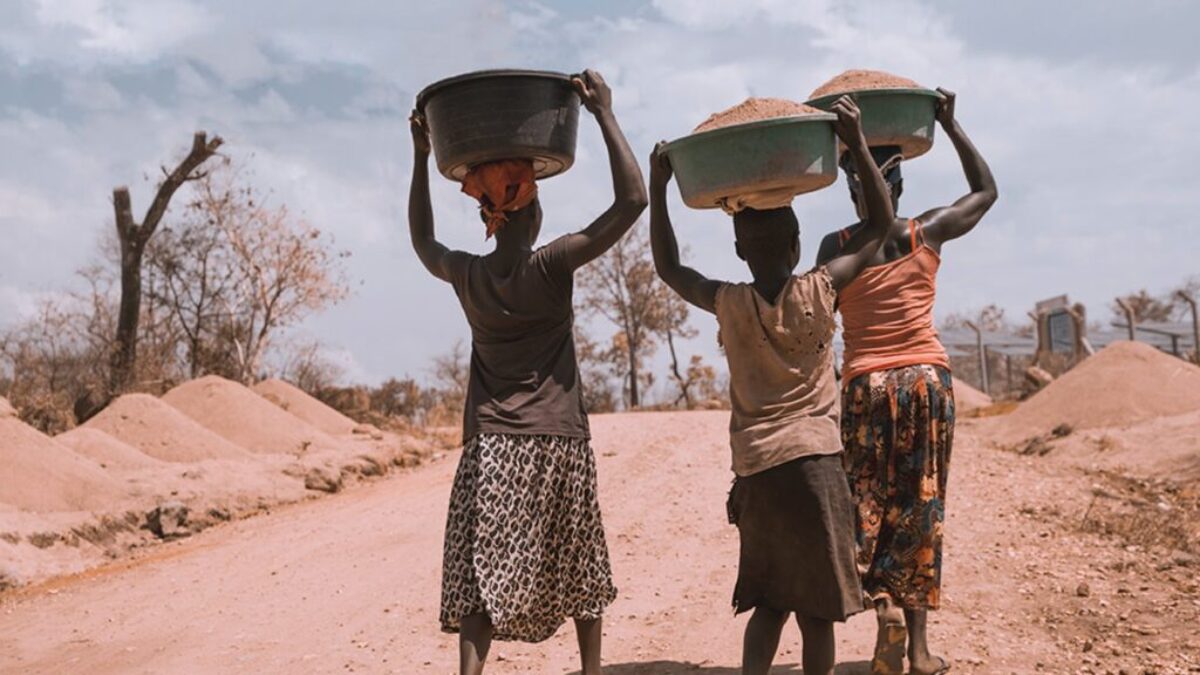 three women carrying basin while walking barefoot