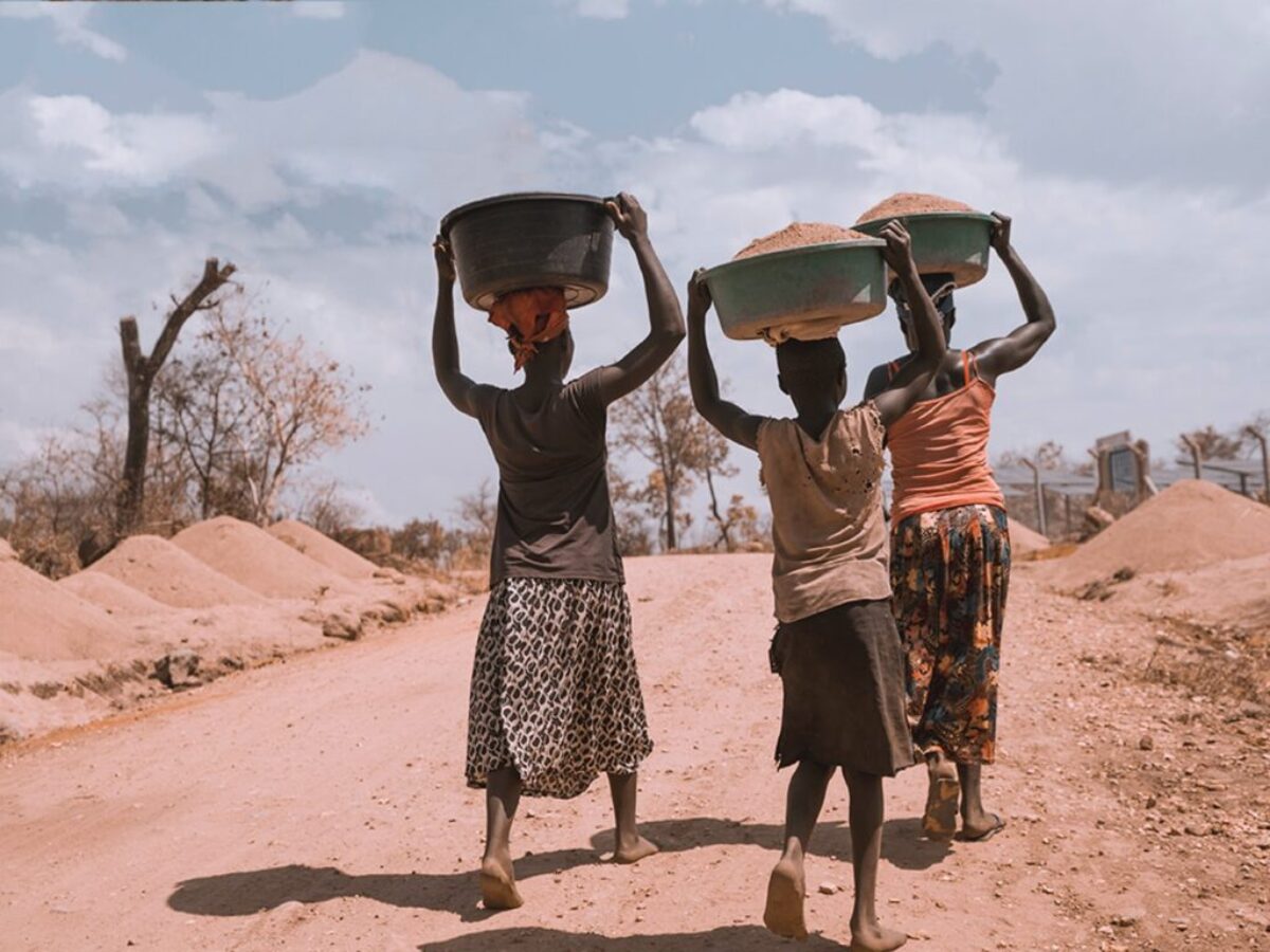 three women carrying basin while walking barefoot