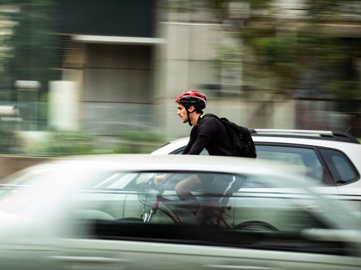 man riding bicycle near car