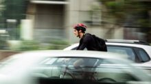 man riding bicycle near car