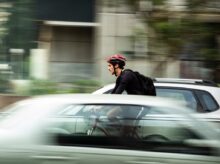man riding bicycle near car