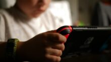 boy in white crew neck t-shirt holding black and red cordless device