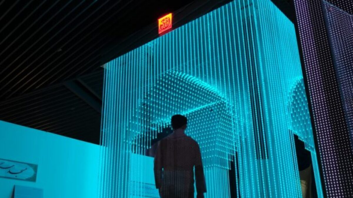 man in black jacket standing on blue lighted room