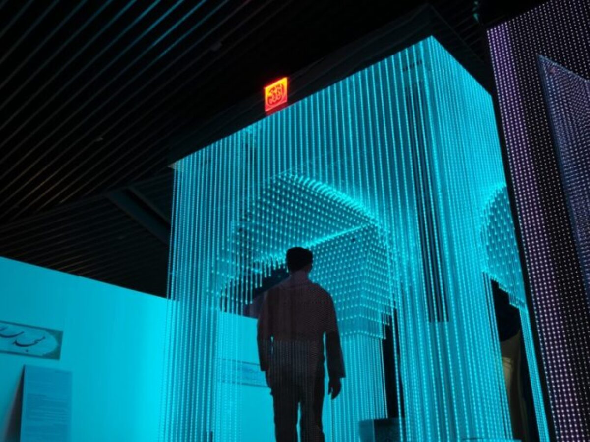 man in black jacket standing on blue lighted room
