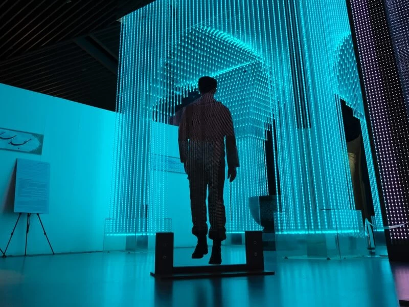 man in black jacket standing on blue lighted room