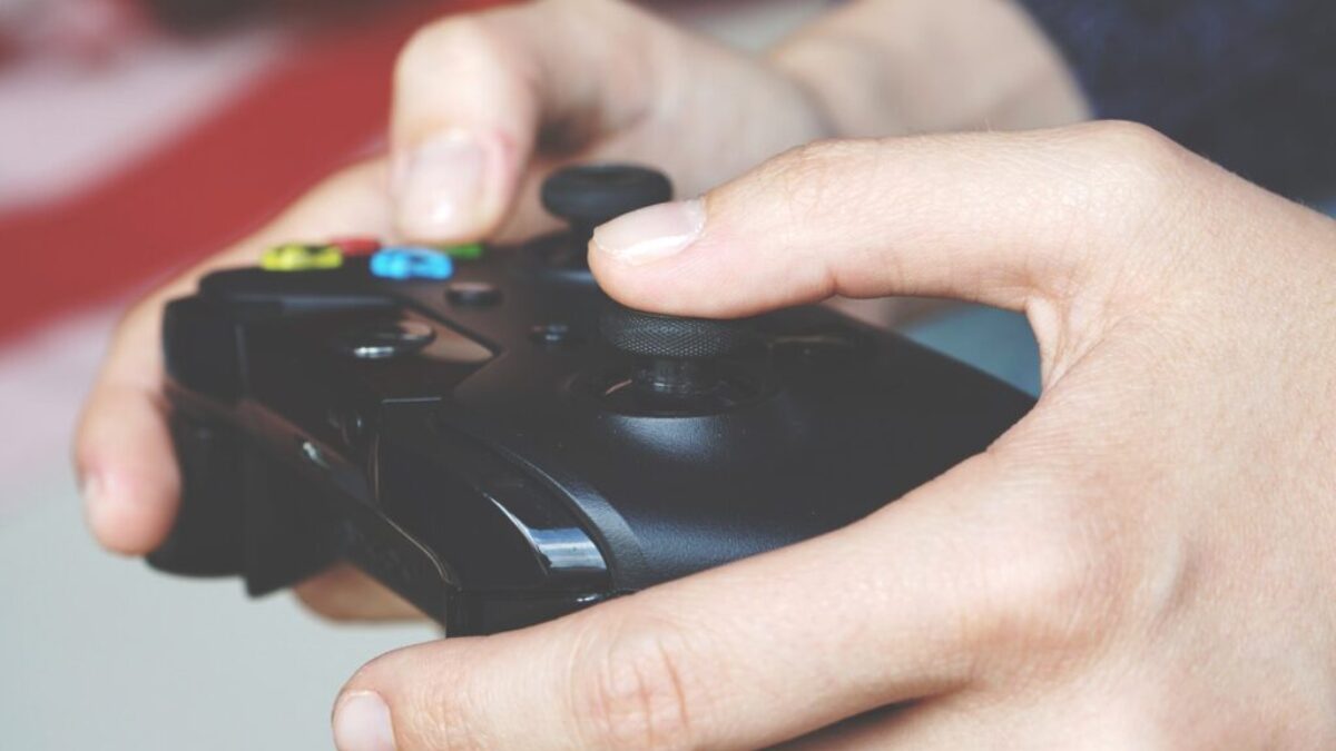 Man Holding Black Game Controller