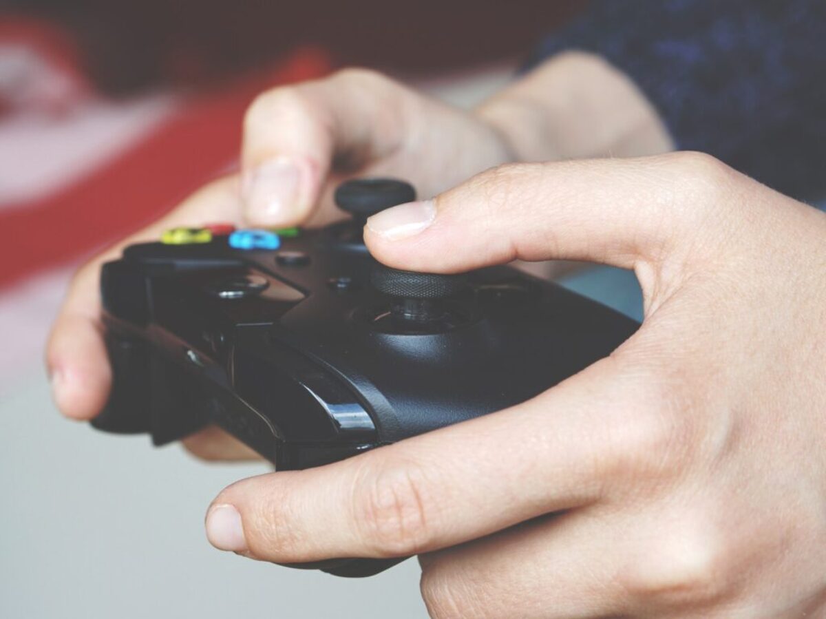 Man Holding Black Game Controller