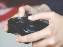 Man Holding Black Game Controller