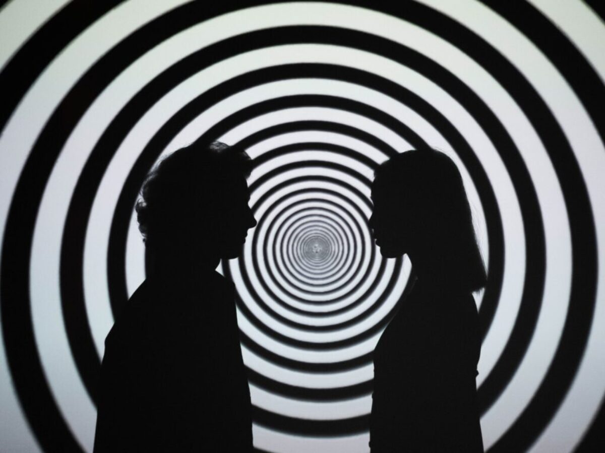 Silhouette of 2 Person Standing in Front of White and Black Stripe Wall
