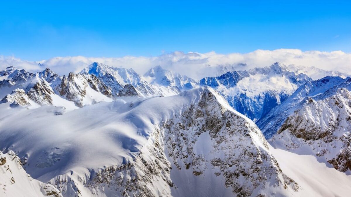 Areal Photography Of Snow Coated Mountains Under Clear Blue Sky