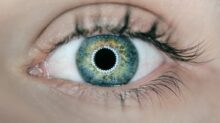 person showing green and black eyelid closeup photography