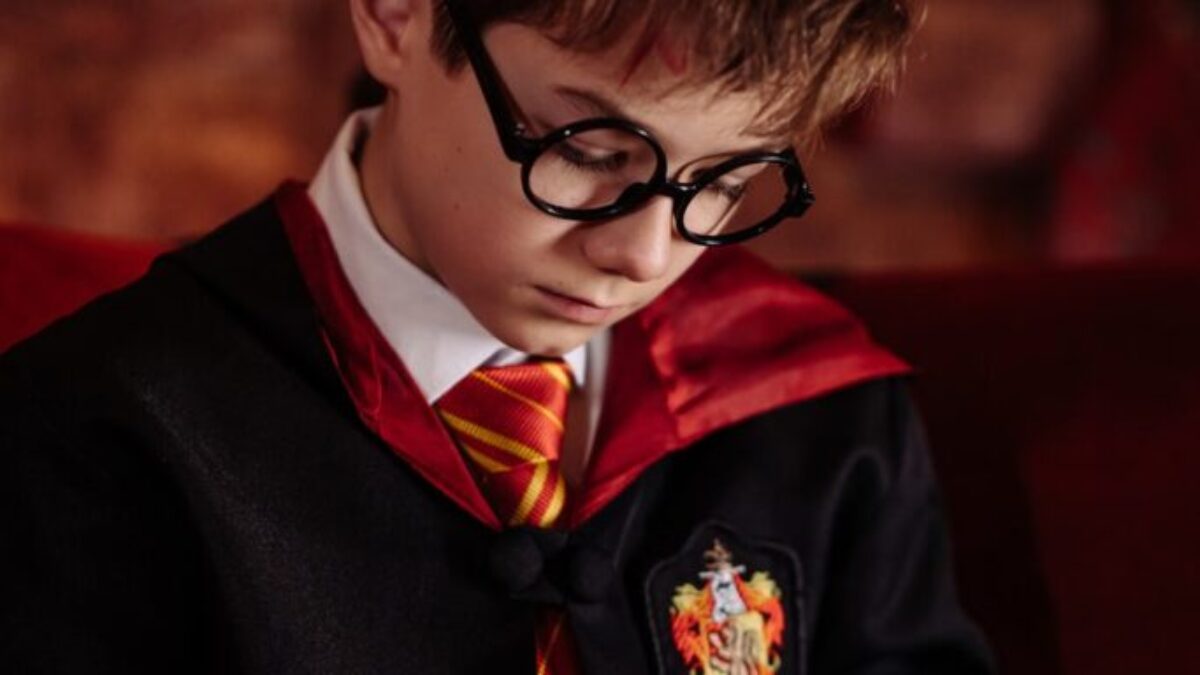 Boy in Black Framed Eyeglasses Reading a Book