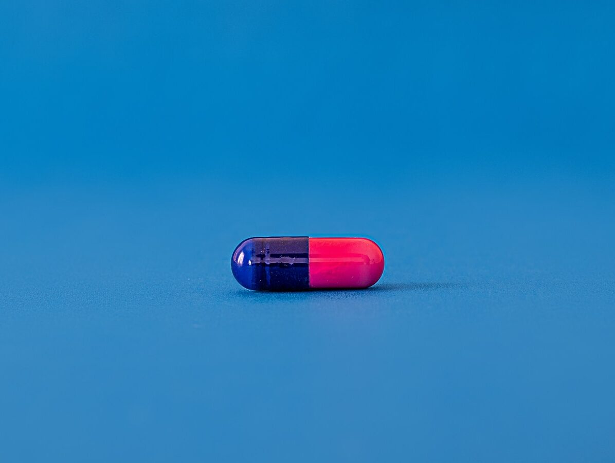 red and blue pill on blue surface