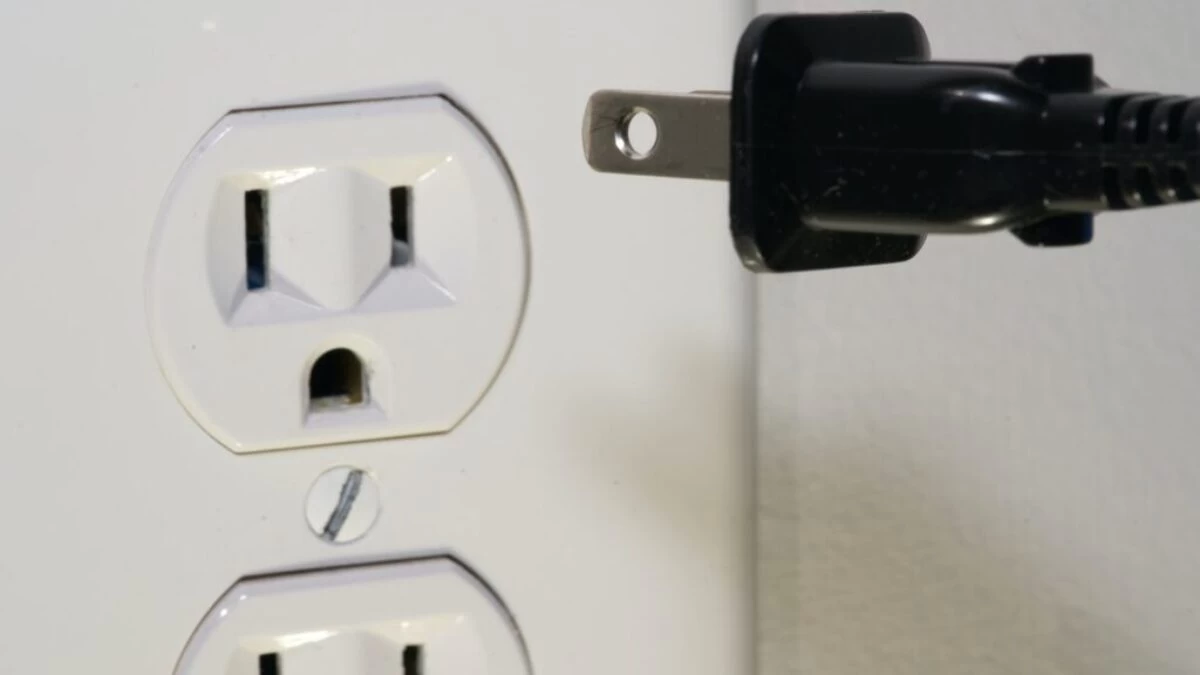black male plug in front of electric socket