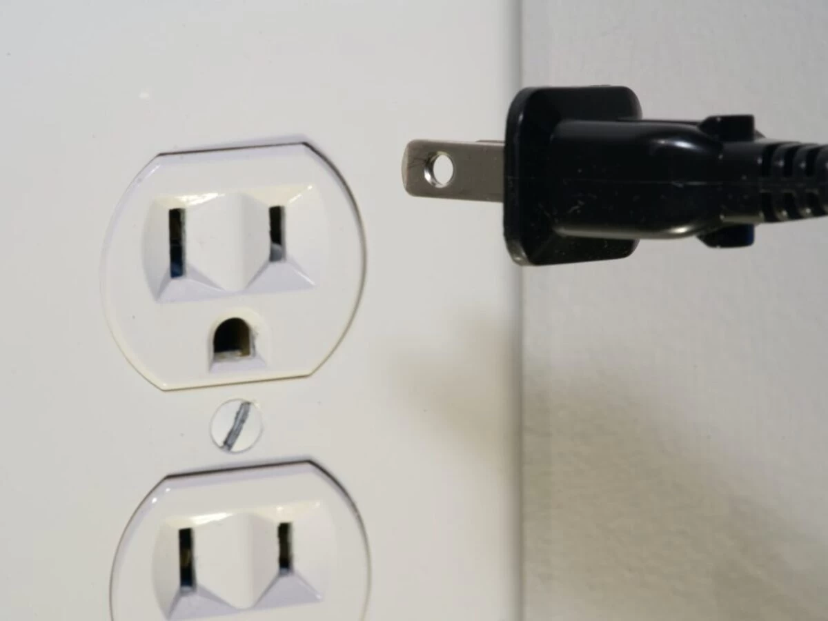 black male plug in front of electric socket