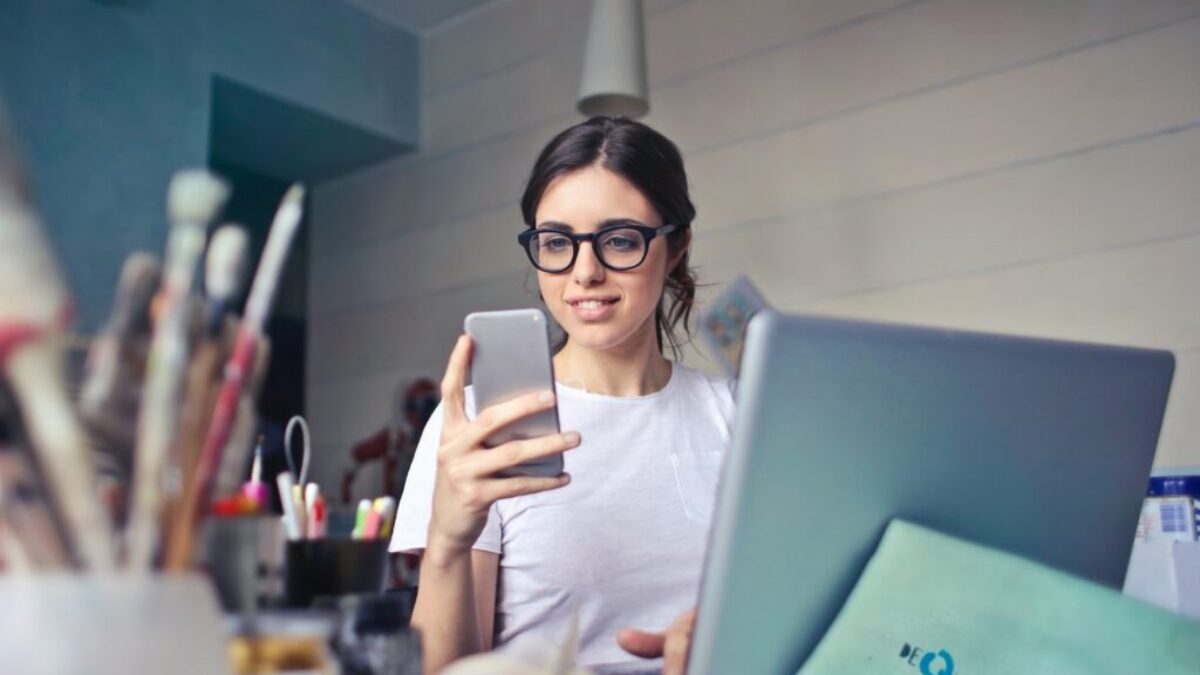 woman in white shirt using smartphone