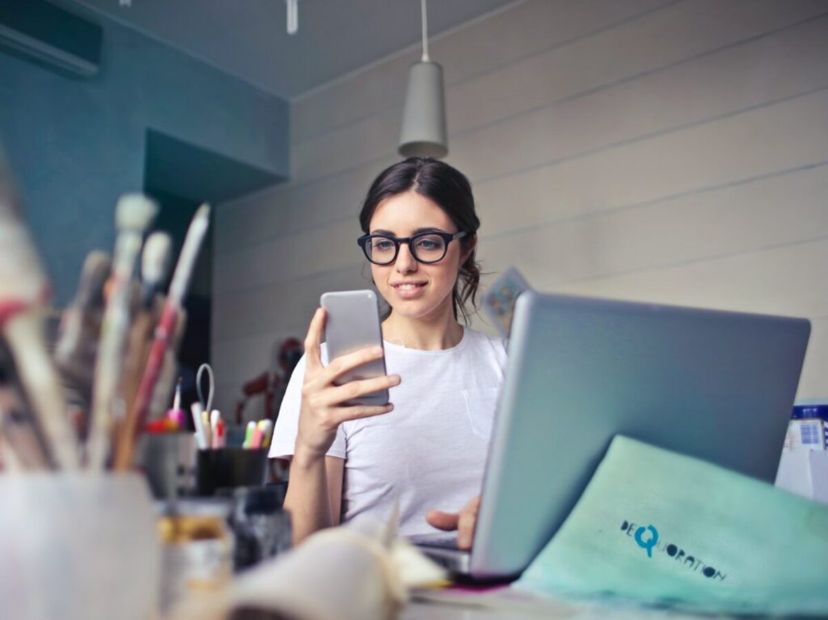 woman in white shirt using smartphone