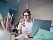 woman in white shirt using smartphone