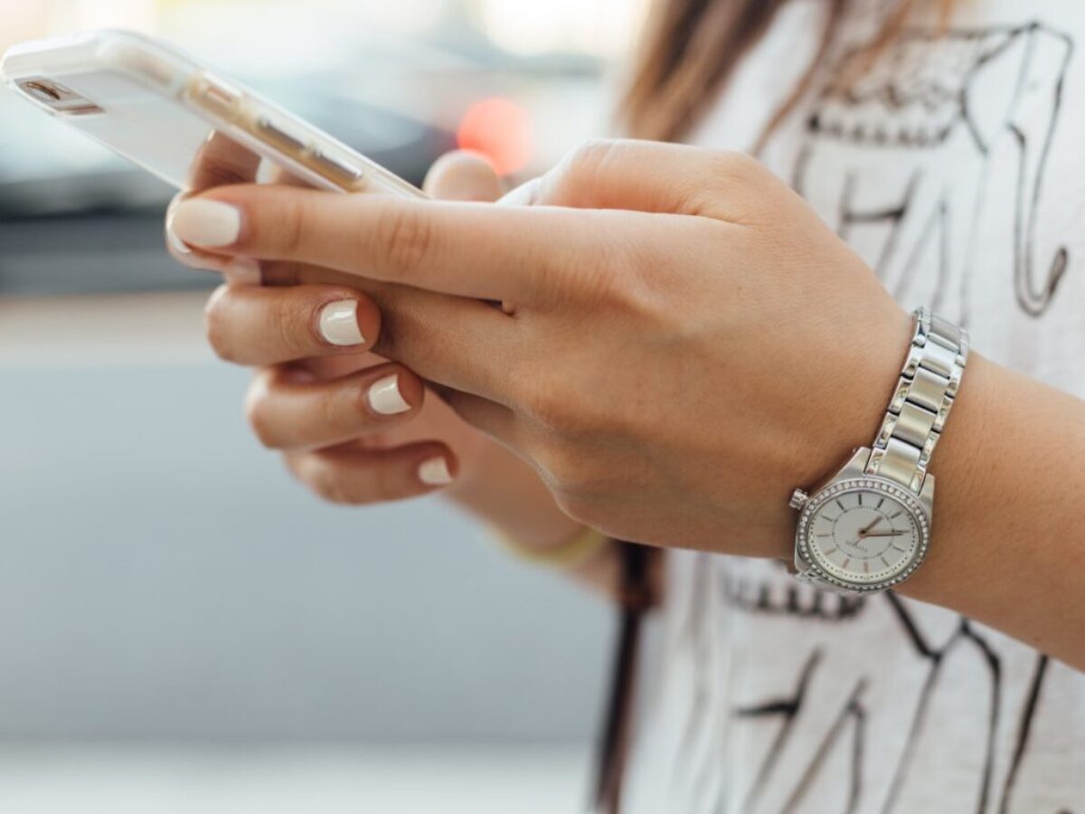 woman holding iPhone during daytime