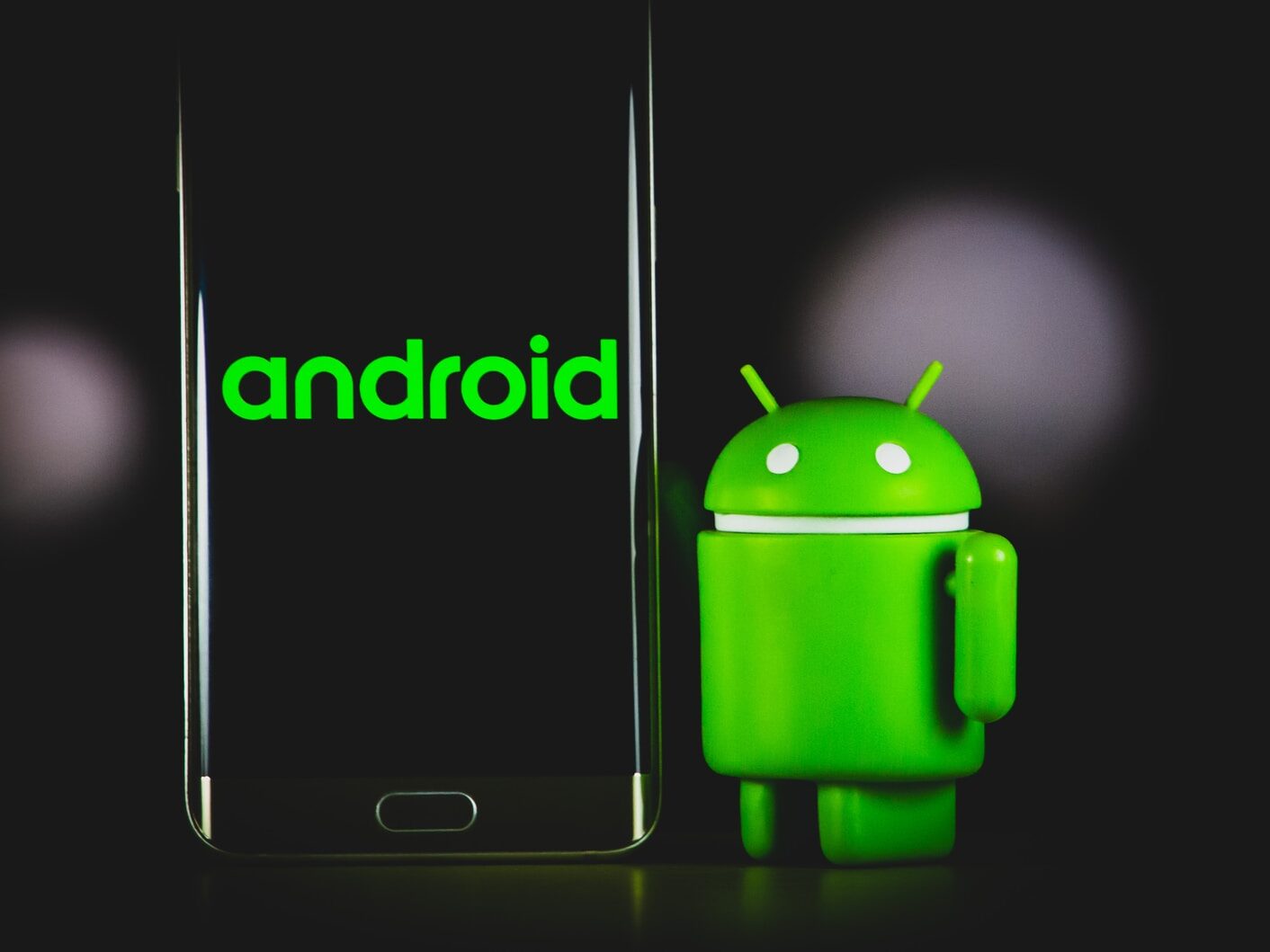 green frog iphone case beside black samsung android smartphone