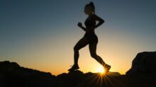 silhouette of man jumping on rocky mountain during sunset