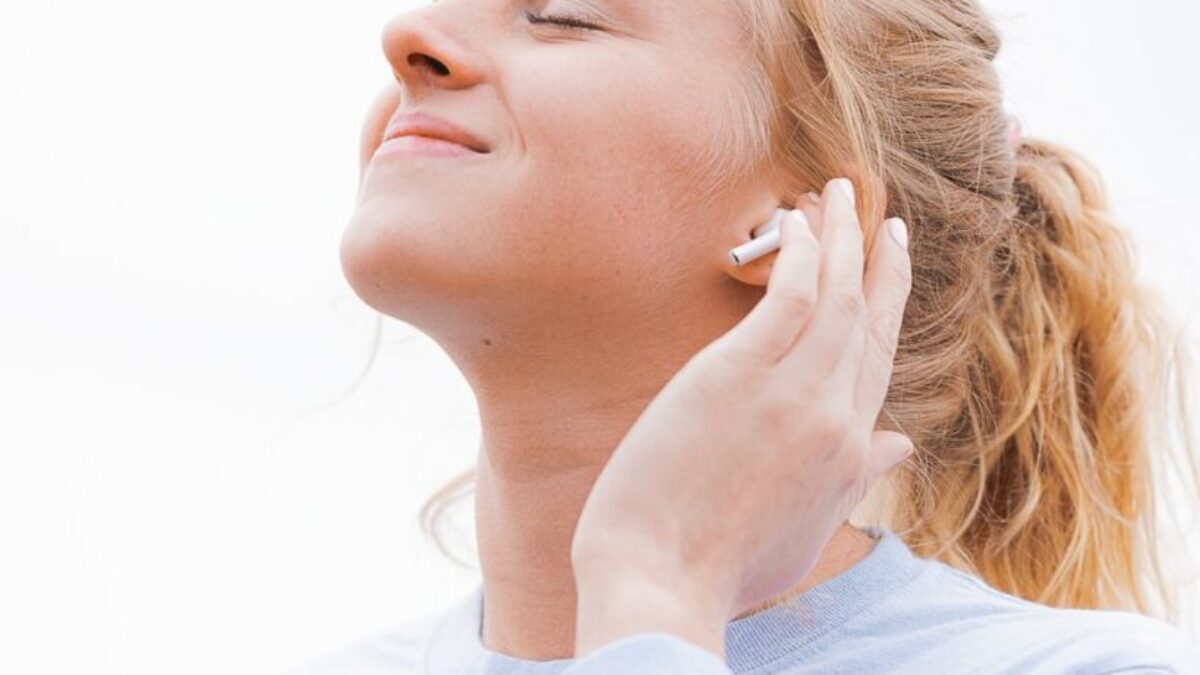 woman in white crew neck shirt covering her face with her hand