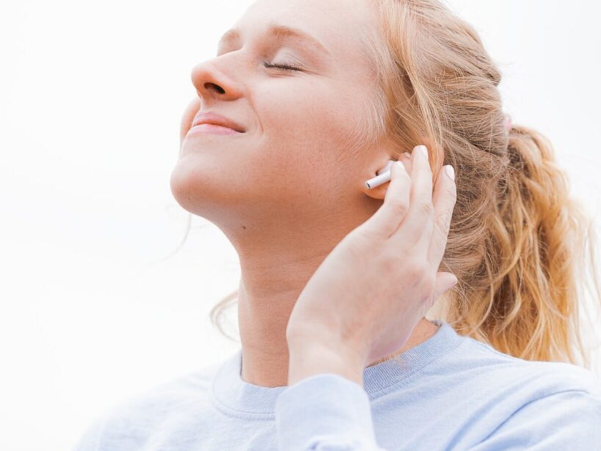 woman in white crew neck shirt covering her face with her hand