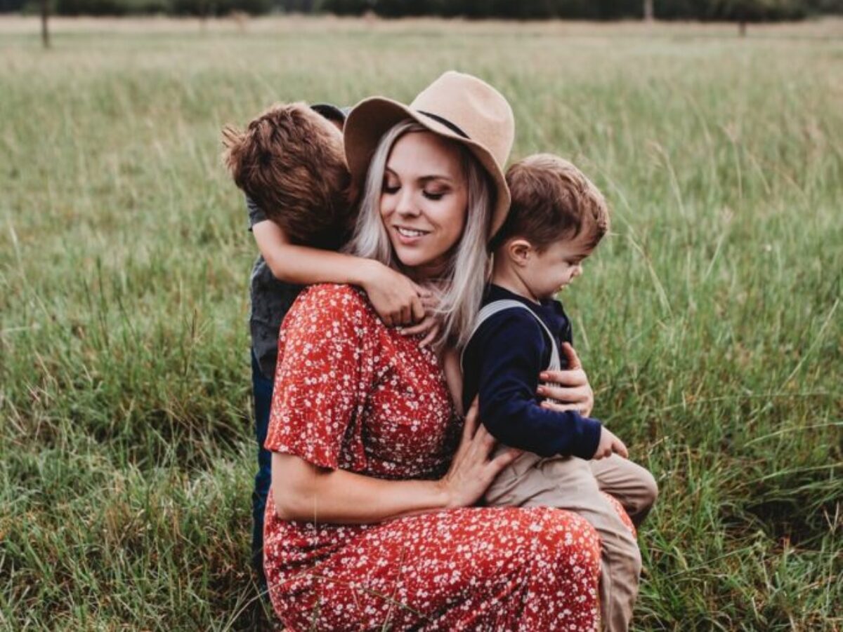 man and two children on grass field
