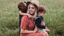 man and two children on grass field