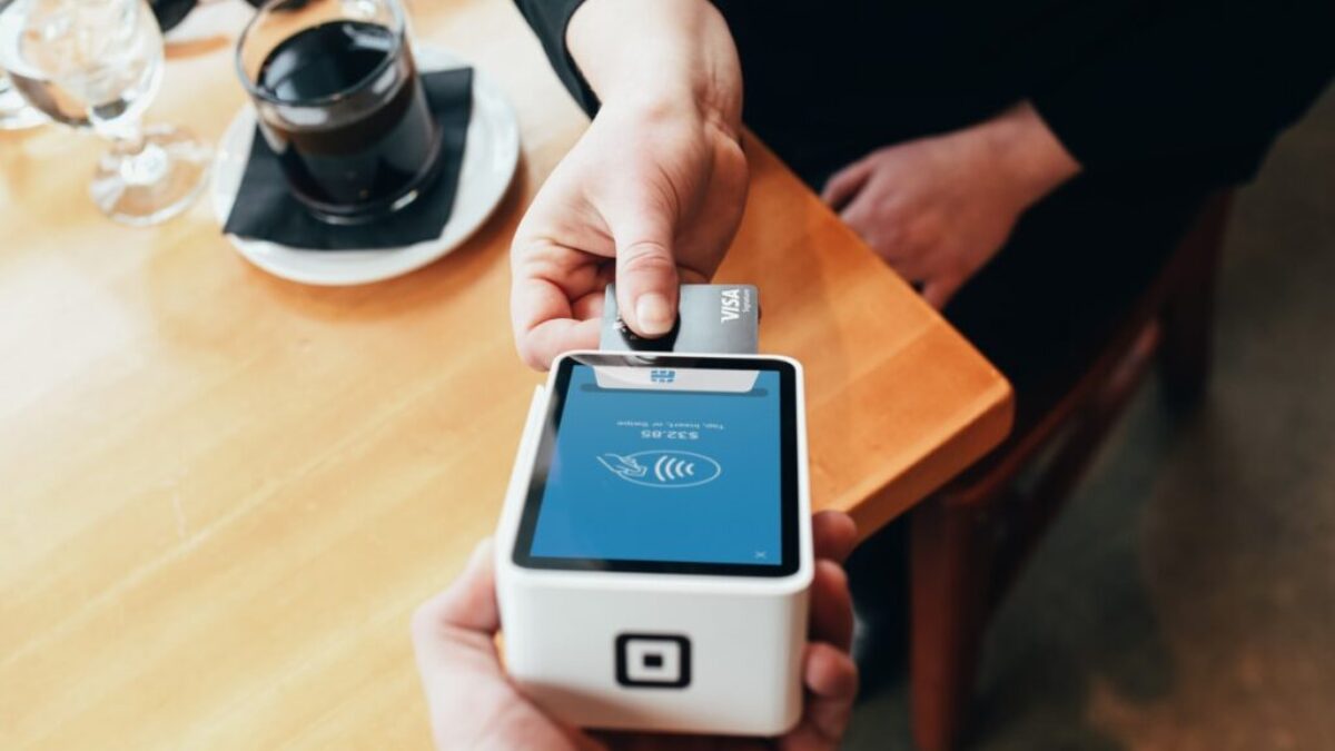 person holding credit card swipe machine
