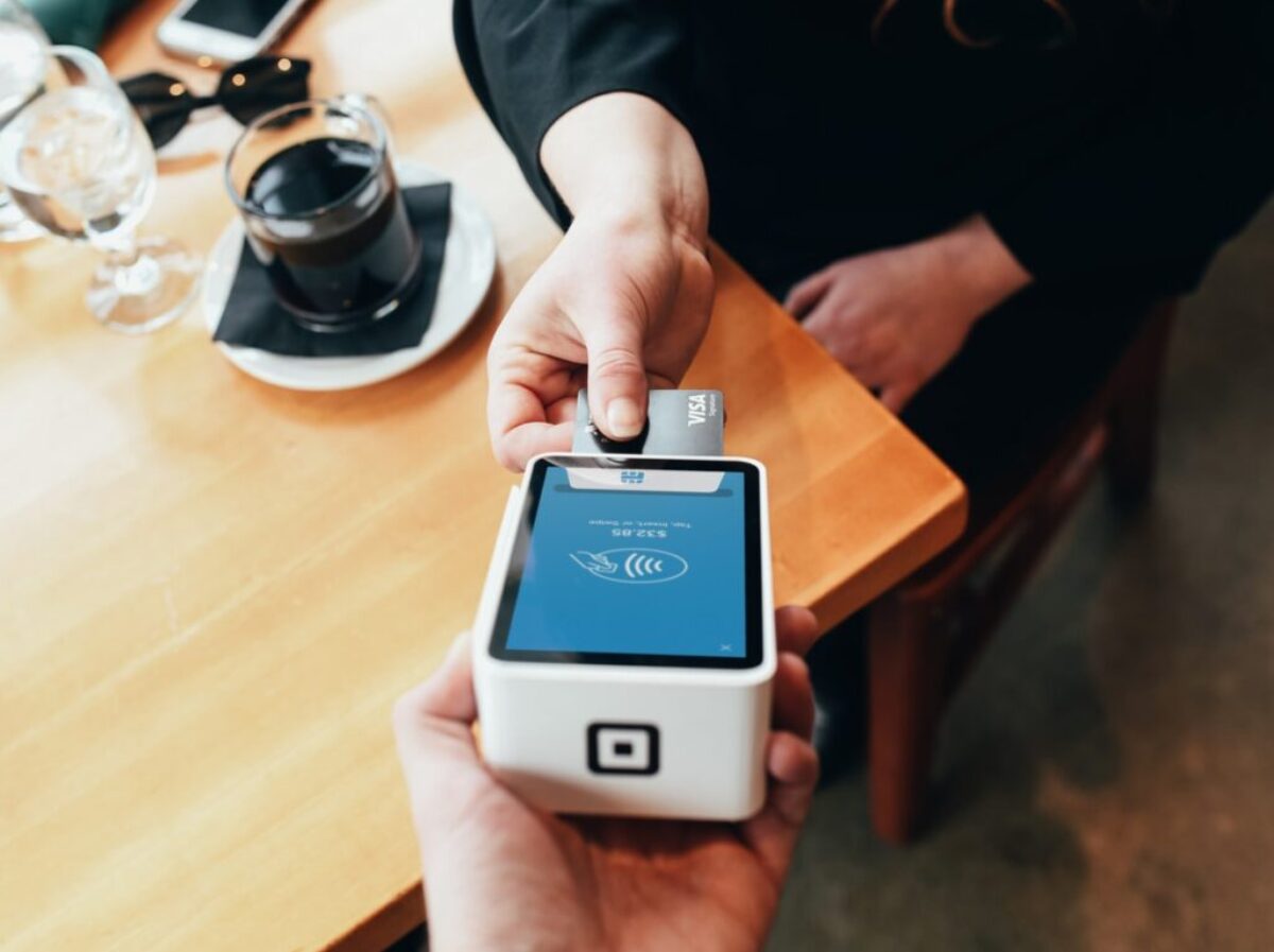 person holding credit card swipe machine