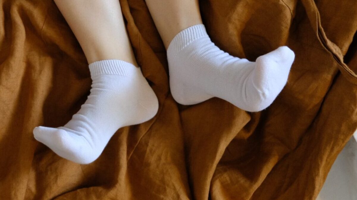 person in white socks on brown textile