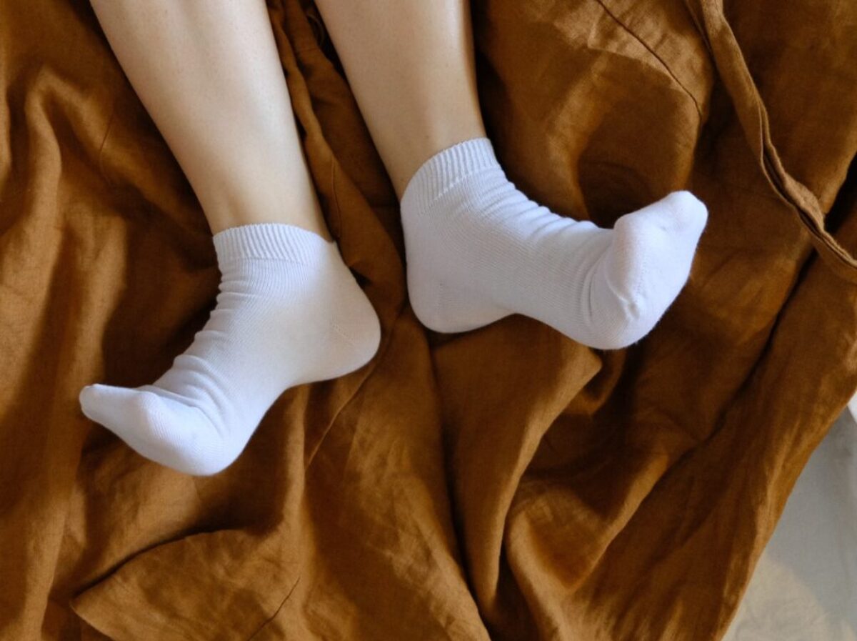 person in white socks on brown textile