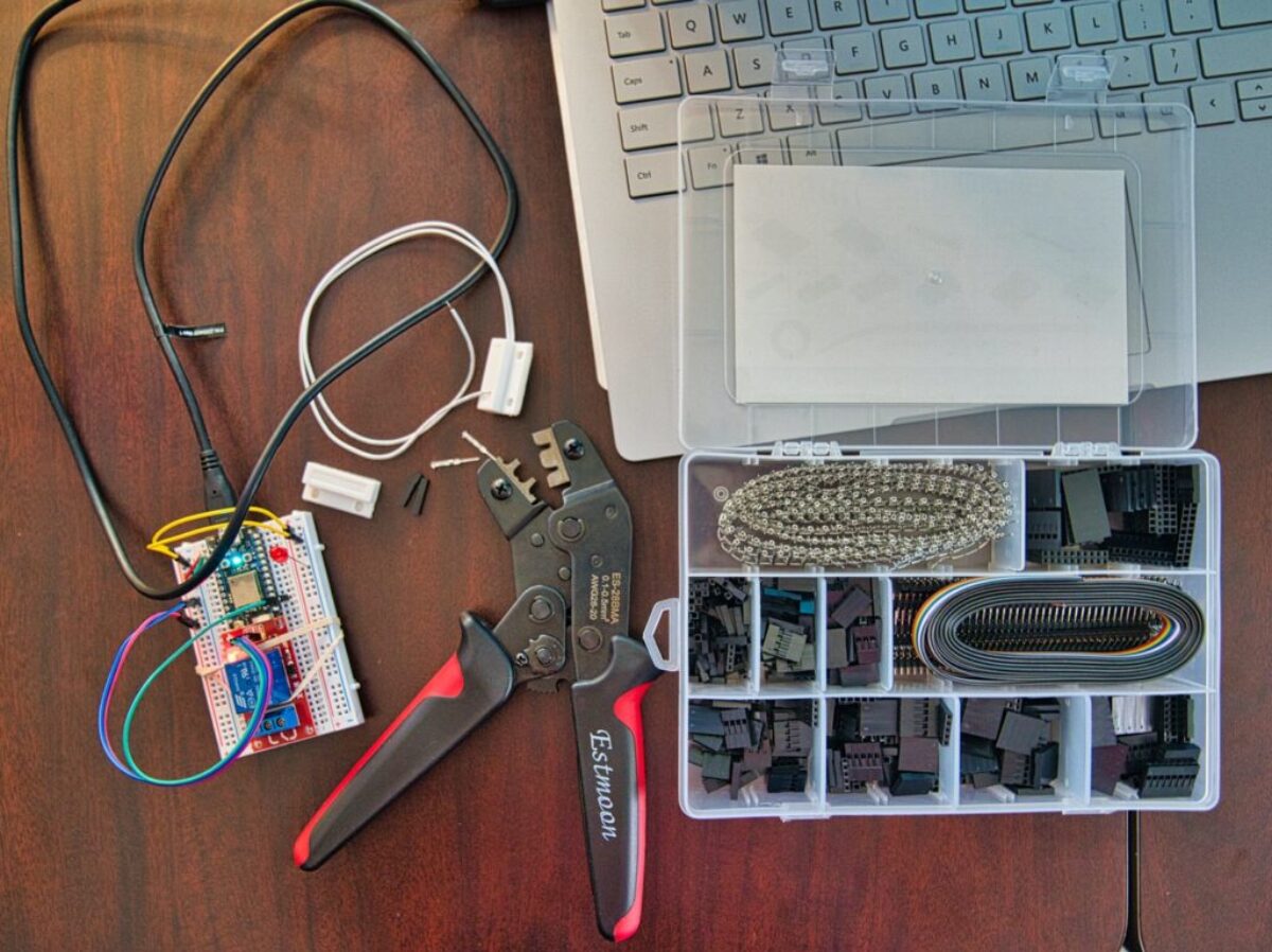 red and silver scissors beside white laptop computer