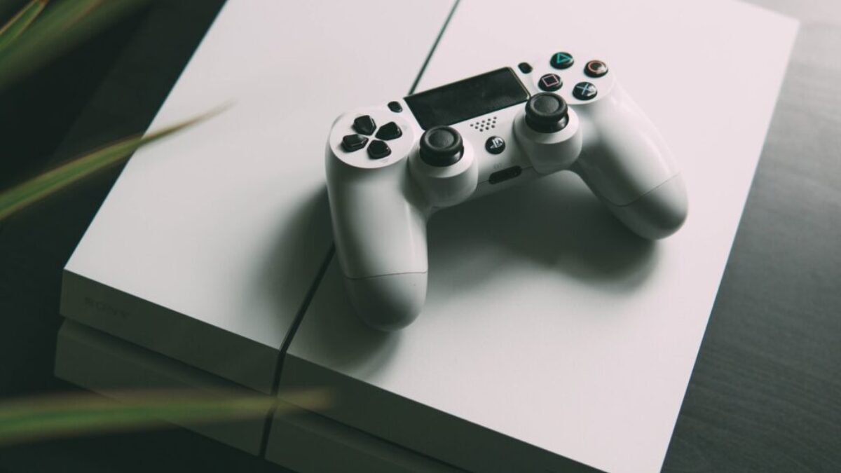 selective focus photography of white Sony PS4 console with wireless controller